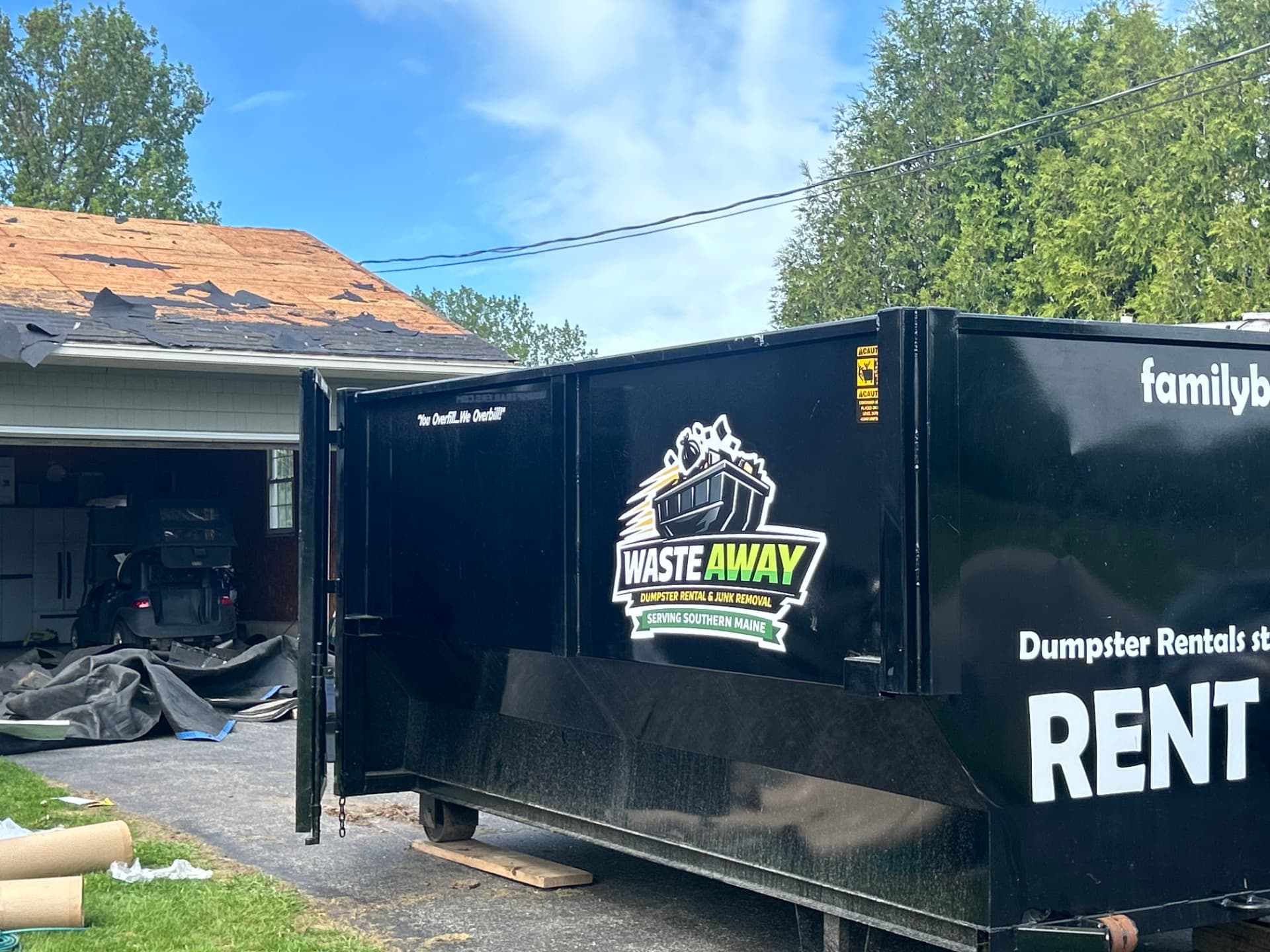 Waste Away roll-off dumpster with the walk-in door open at a roofing job