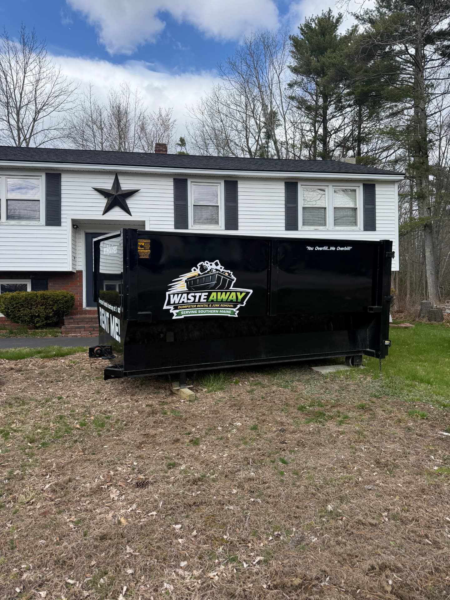 Waste Away 16-yard dumpster set beside a Maine home