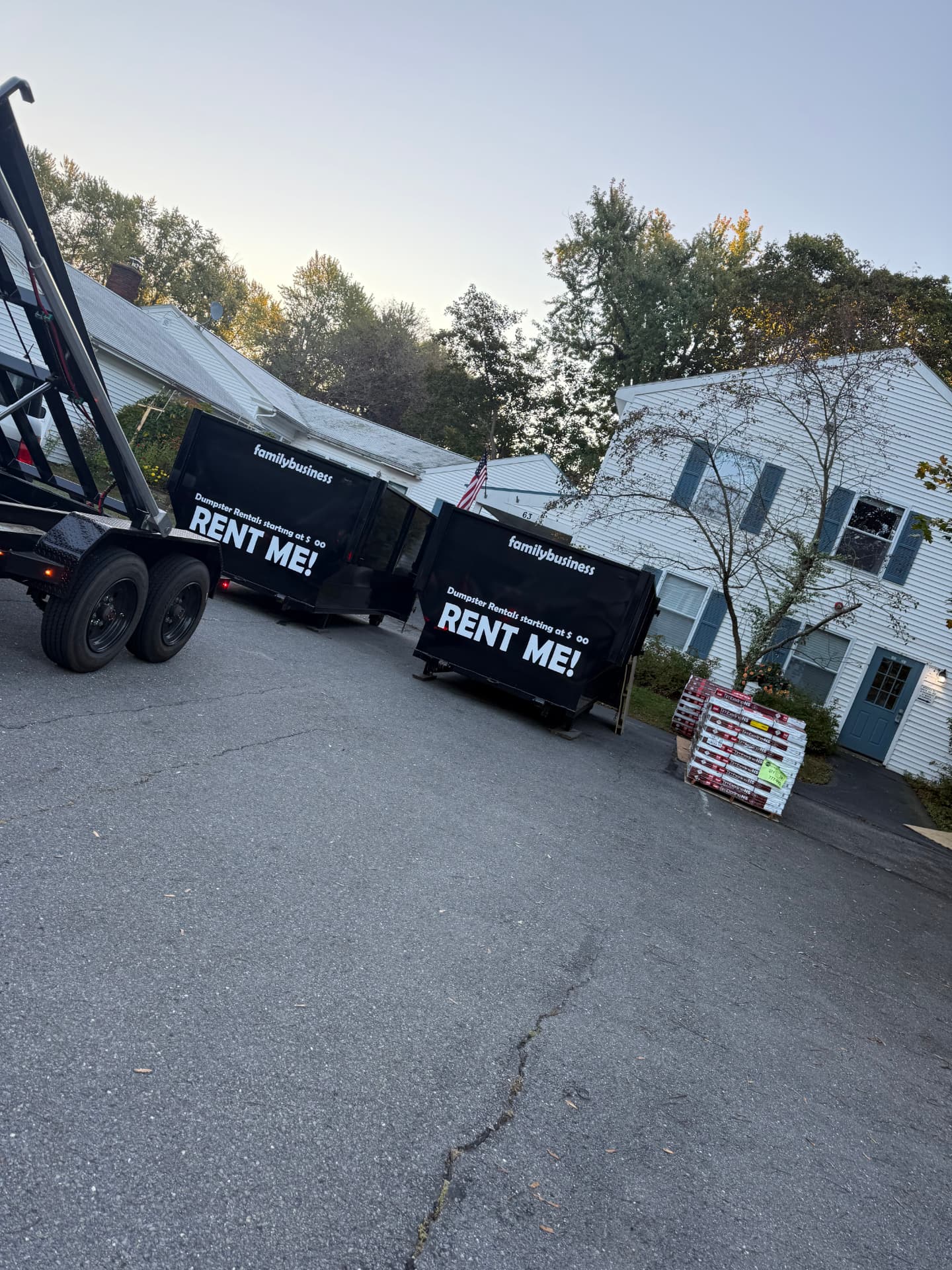 Two Waste Away dumpsters staged in a driveway at dusk